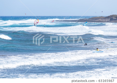 Surfers and windsurfers on the waves of El Medano Surfers and windsurfers on the waves of El Medano 63165987