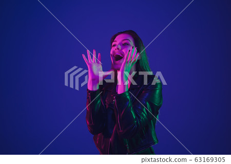 Caucasian woman's portrait isolated on blue studio background in neon light 63169305