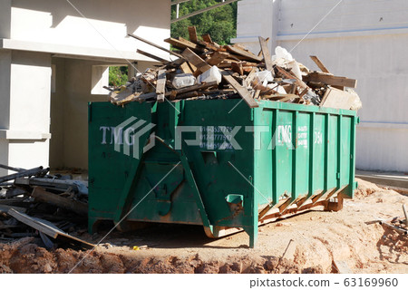 Huge wasted disposal bin used to collect rubbish and unused material from the construction site. Has a fixed collection schedule 63169960