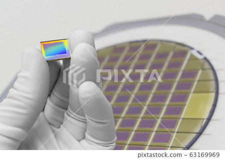 Hand in white glove holding microchip photo sensor 63169969