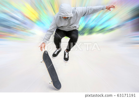 young skater doing jump trick at skate park. young skater doing jump trick at skate park. 63171191