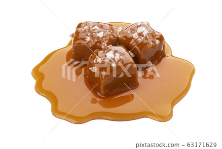 Toffee candies with caramel sauce and salt isolated on white background 63171629