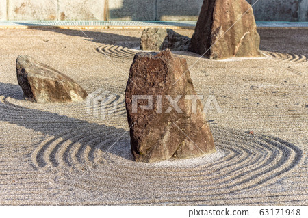 Japanese dry rock zen landscape garden, or karesansui, with raked sand or gravel to represent ripples in water. Kurikarafudoji temple, Tsubata, Japan. 63171948