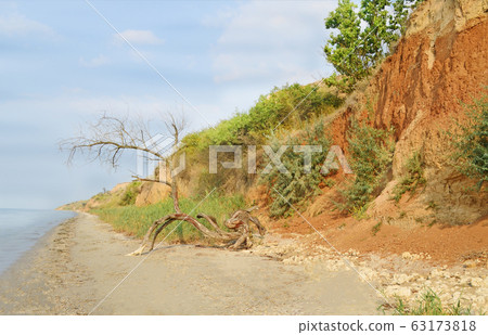 Orange clay canyon on the beach. Beach with red Orange clay canyon on the beach. Beach with red 63173818