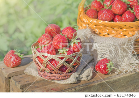 Strawberries with leaves in wicker basket 63174046
