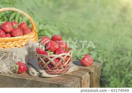 Strawberries in basket on wooden table outdoor 63174049