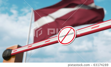 Barrier gate with STOP CORONAVIRUS sign being closed with flag of Latvia as a background. Latvian quarantine. 3D rendering Barrier gate with STOP CORONAVIRUS sign being closed with flag of Latvia as a background. Latvian quarantine. 3D rendering 63174289