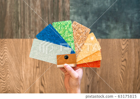 man selects the color decor new floors of different colored sample in a furniture store and floors 63175815