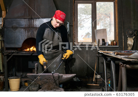 female blacksmith metal artist forges a figured 63176305