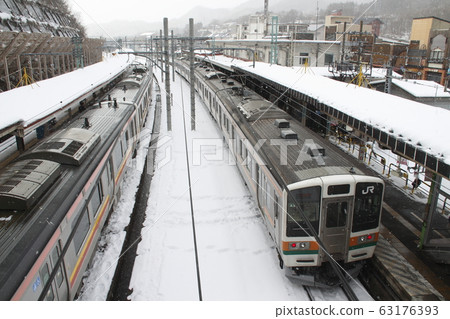 The Joetsu Line 211 which is stopping at Wataru Suidobashi Station in winter The Joetsu Line 211 which is stopping at Wataru Suidobashi Station in winter 63176393