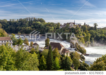 Rheinfall the large and powerful waterfall surround with green forest and blue sky background view from Neuhausen am Rheinfall railway station in switzerlad 63176933