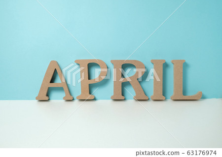 Wooden alphabet block of "APRIL" in light blue and white background (overview) 63176974
