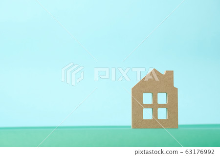 Wooden blocks in shape of house on green and light blue background Wooden blocks in shape of house on green and light blue background 63176992
