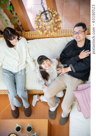 Image of three parents and children (father, mother, daughter) relaxing on the sofa 63180523