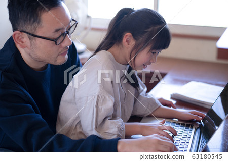Image of a girl having her father teach her computer 63180545