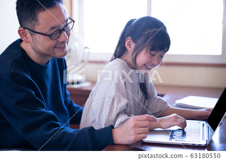 Image of a girl having her father teach her computer 63180550