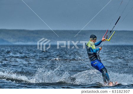 A male kiter slides on the surface of the water. 63182307