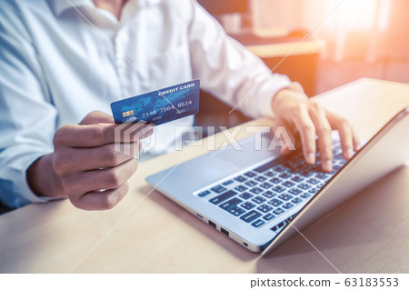 Young man use credit card for online shopping Young man use credit card for online shopping 63183553