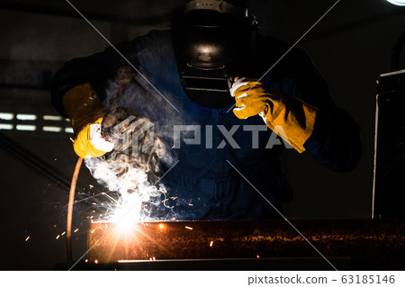 Metal welder working with arc welding machine. Metal welder working with arc welding machine. 63185146