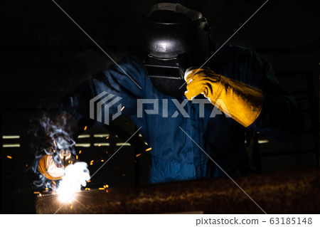 Metal welder working with arc welding machine. 63185148
