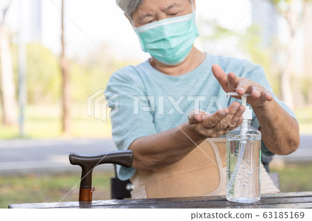 Asian elderly people wearing protective mask,using alcohol antiseptic gel,prevent infection,outbreak of Covid-19,senior woman washing hand with hand sanitizer to avoid contaminating with Coronavirus   63185169