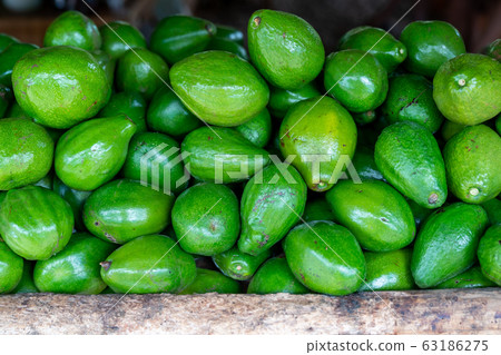 Green avocado stack at grocery 63186275