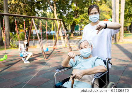 Senior mother and daughter show thumbs down,family wearing medical mask,asian people prevent the Covid-19 infection,epidemic,spread of germs,outbreak Coronavirus,concept of Covid-19 virus quarantine Senior mother and daughter show thumbs down,family wearing medical mask,asian people prevent the Covid-19 infection,epidemic,spread of germs,outbreak Coronavirus,concept of Covid-19 virus quarantine 63186870