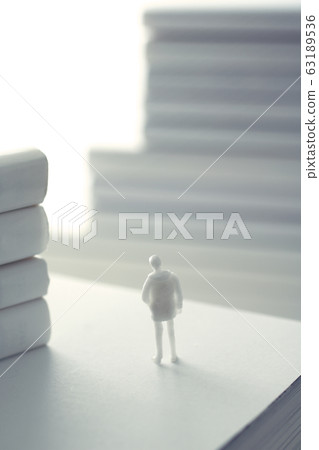 Stacked white books and human Stacked white books and human 63189536