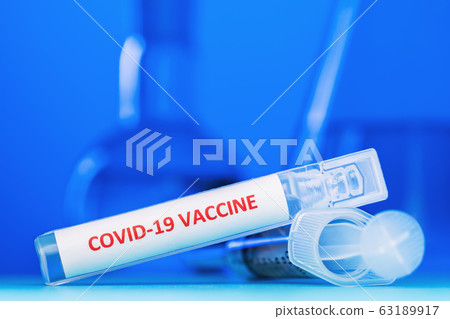 Ampoule with a vaccine against coronavirus COVID-19 on a blue background, close-up. The concept of the victory over the virus Ampoule with a vaccine against coronavirus COVID-19 on a blue background, close-up. The concept of the victory over the virus 63189917