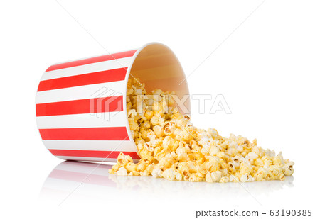 Scattered popcorn from paper striped bucket isolated on white background Scattered popcorn from paper striped bucket isolated on white background 63190385