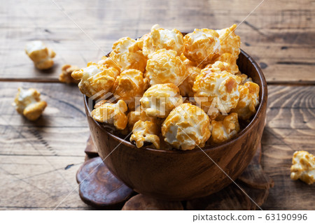 Popcorn in caramel glaze in wooden plates on a Popcorn in caramel glaze in wooden plates on a 63190996