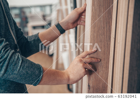 Male selects wooden floor of the sample in the specialized trade Male selects wooden floor of the sample in the specialized trade 63192041