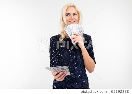 portrait of a successful woman in a dress holding a bunch of money in her hands on a white 63192288