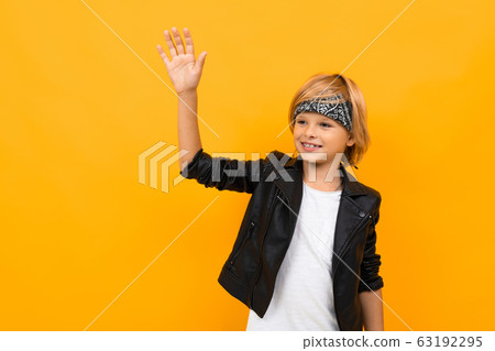 Stylish young boy in black jacket and white t-shirt rejoices Stylish young boy in black jacket and white t-shirt rejoices 63192295