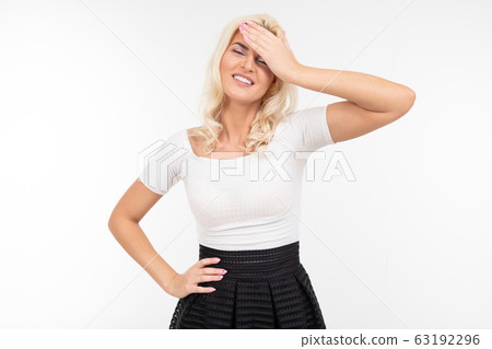 girl shows a headache while holding a hand near the forehead on a white background girl shows a headache while holding a hand near the forehead on a white background 63192296
