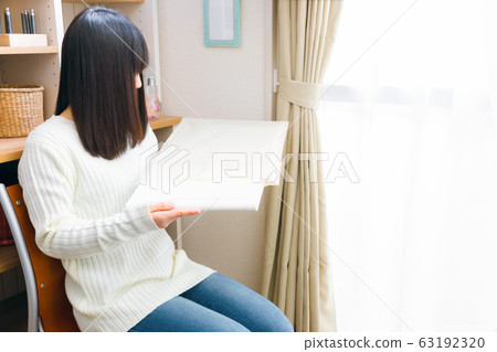 Woman taking out the album 63192320