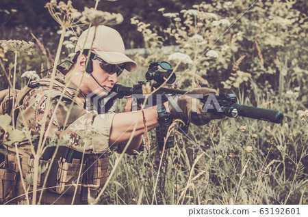 A military man or airsoft player in a camouflage A military man or airsoft player in a camouflage 63192601