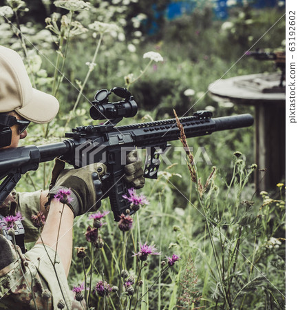 A military man or airsoft player in a camouflage A military man or airsoft player in a camouflage 63192602