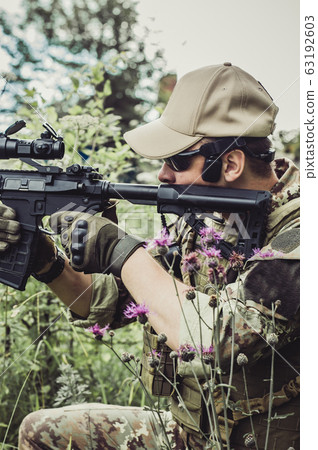 A military man or airsoft player in a camouflage A military man or airsoft player in a camouflage 63192603