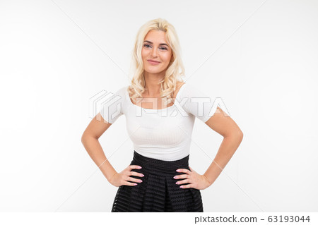 pretty blonde woman in white t-shirt posing with hands on hips on a white background pretty blonde woman in white t-shirt posing with hands on hips on a white background 63193044