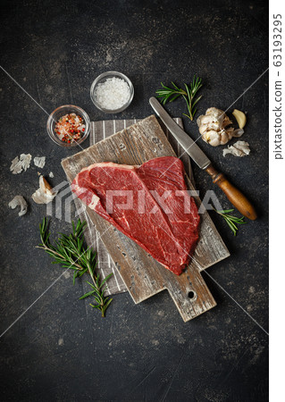 Raw beef steak with spices. 63193295