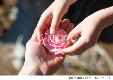 遞粉紅色花的父母和孩子手 63194281