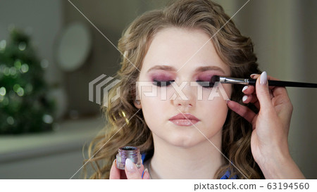 Work of a makeup artist. Applying shadows to the Work of a makeup artist. Applying shadows to the 63194560