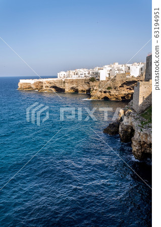 Houses on dramatic cliffs over Adriatic sea in Polignano a Mare, Italy, sunny summer day Houses on dramatic cliffs over Adriatic sea in Polignano a Mare, Italy, sunny summer day 63194951