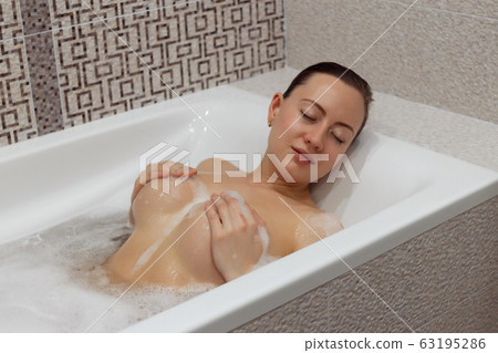 Nude girl takes a bubble bath 63195286