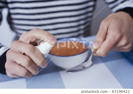 man at a table disinfecting a spoon man at a table disinfecting a spoon 63196422
