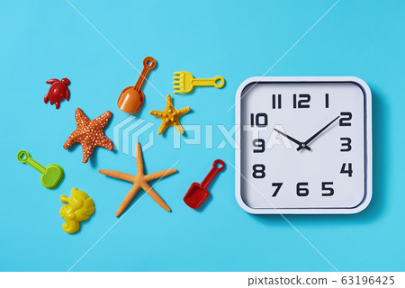 clock and beach toys on a blue background clock and beach toys on a blue background 63196425