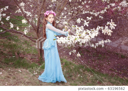 Cute girl near the magnolia tree. Cute girl near the magnolia tree. 63196562