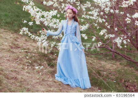 Portrait of a beautiful pensive girl in a magnolia 63196564