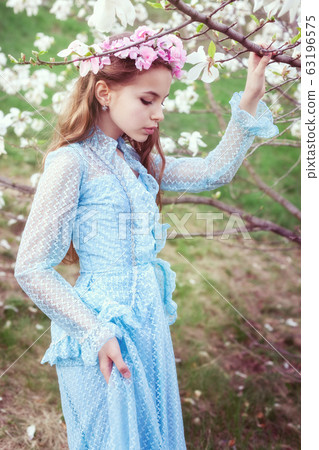 Attractive girl near the tree of magnolia. 63196575